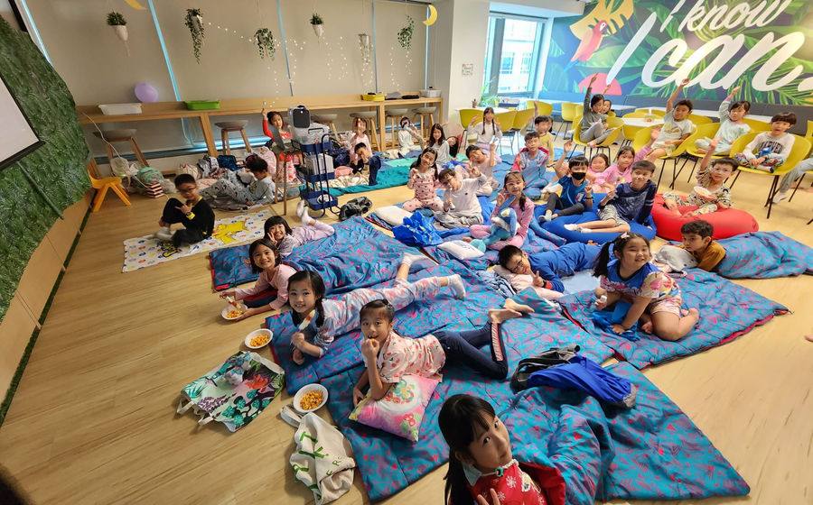 Children settled on sleeping bags for movie night.